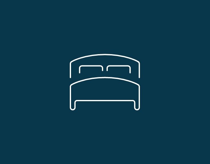 Pictogram of a bed with a headboard and two pillows on a dark blue background