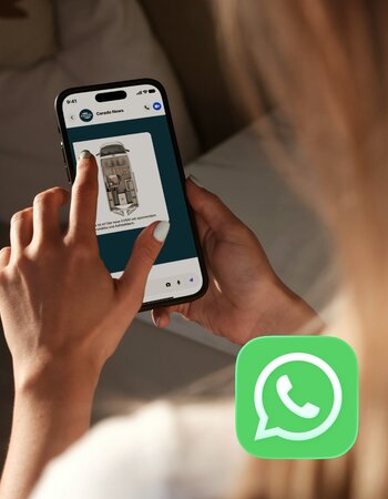Person nutzt WhatsApp auf Smartphone mit Carado News und Wohnmobil-Grundriss