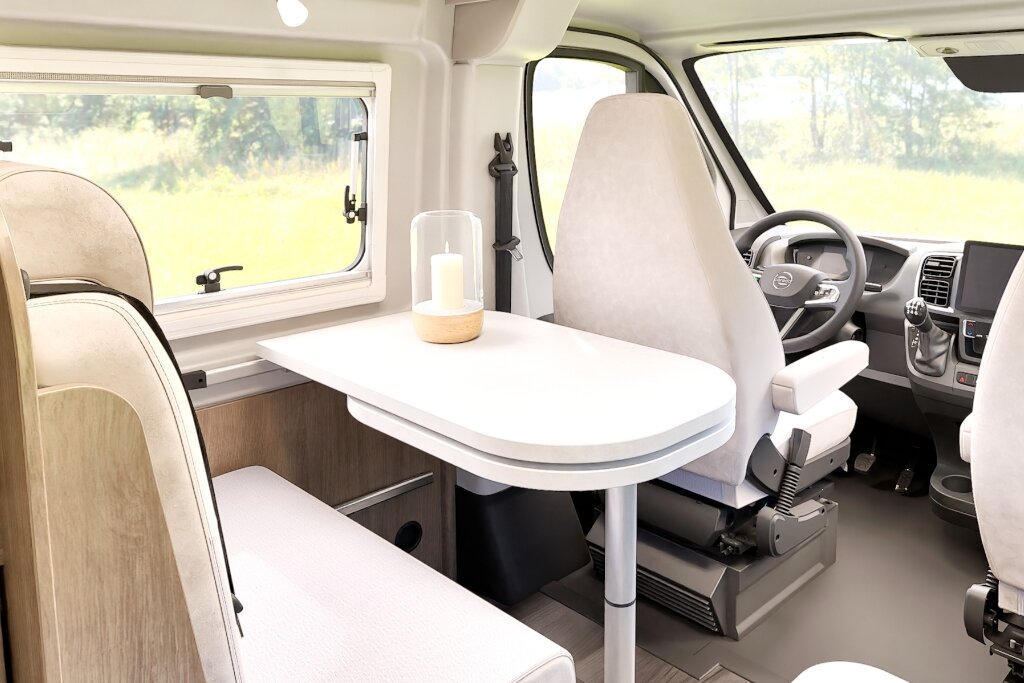 Carado motorhome interior with lounge area, table and swivelling cab seats