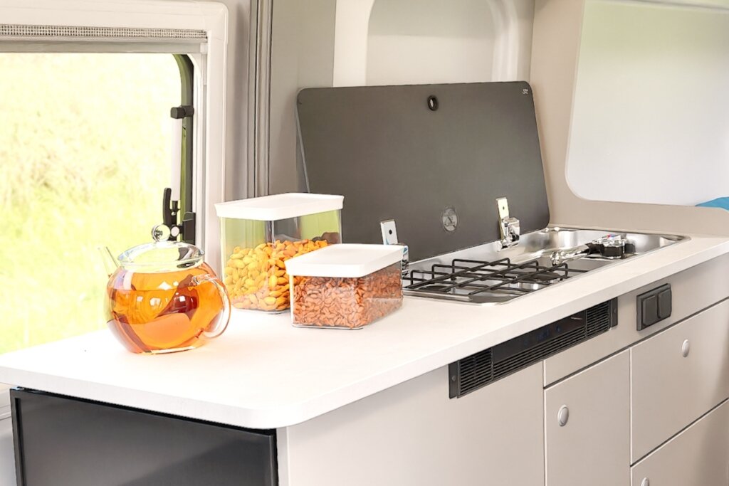 Carado motorhome kitchen with gas hob, sink, worktop and storage containers by the window