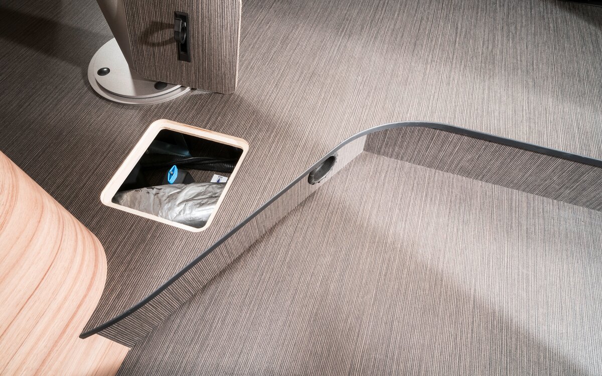 Open service compartment in the floor under the seating area for additional storage space in the HYMER Exsis-t