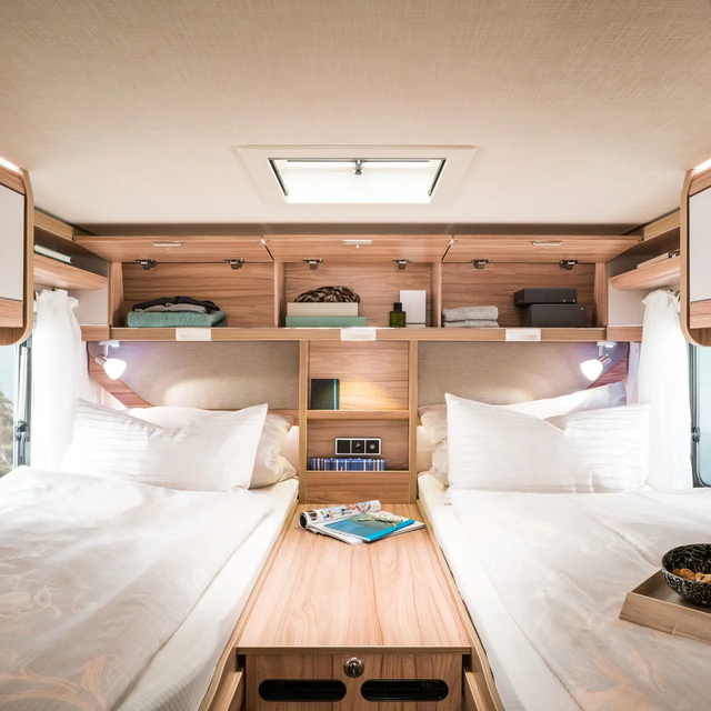 Open overhead lockers filled with utensils and storage compartments in the rear / sleeping area of the HYMER Exsis