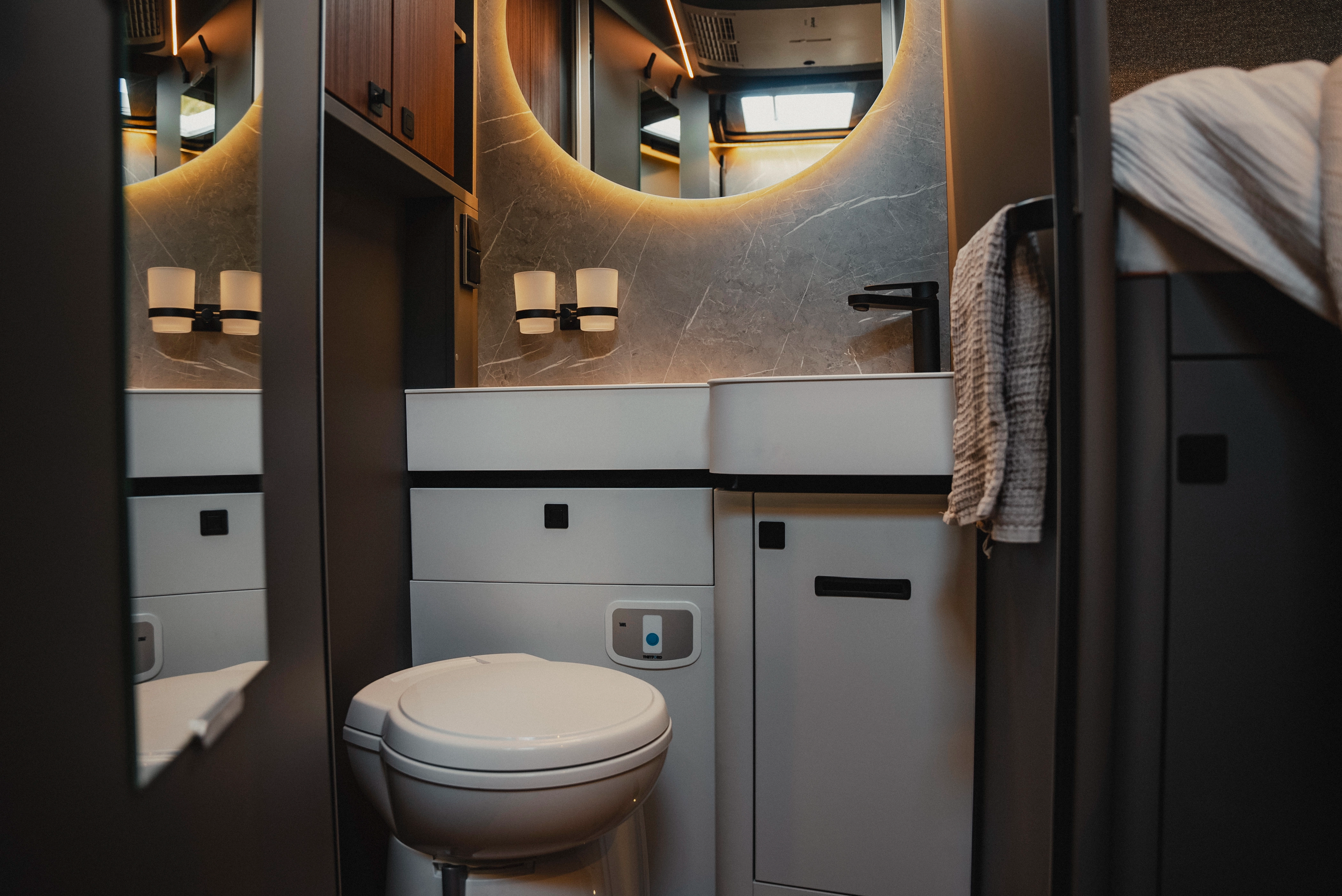 The stylish bathroom offers a modern wash area, characterised by smart design and modern equipment. Experience functionality and elegance in a room that is perfectly tailored for travel and creates an inviting atmosphere.