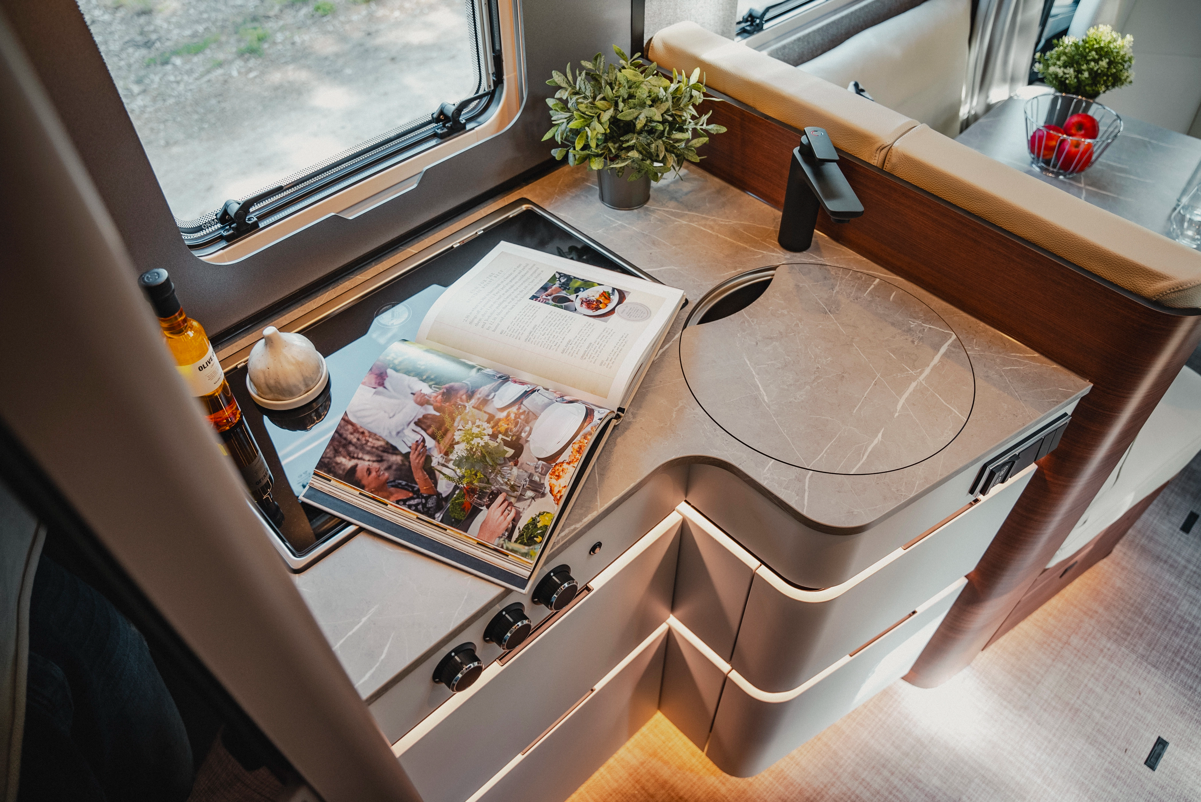 Perfect for wonderful cooking moments on the road: The stylish, light-filled kitchen in Rochefort walnut furniture decor with light grey fronts.