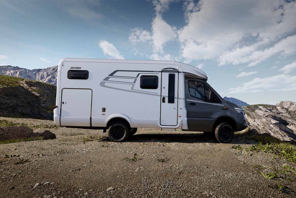 The HYMER ML-T in profile against a mountain panorama.